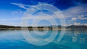 view of azure sea against distant islands blue sky fleecy clouds