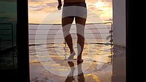 View from back of young man runs and jumps to the swimming pool splashes of water on summer vacations during sunset