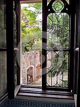 View of the backyard through a half-open window in the castle