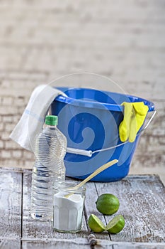 View of baking soda with ,blue, bucket, mop, gloves, lemon, vinegar, glove, natural mix,for effective house cleaning,on