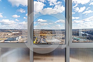 View from the balcony to the river and the industrial area with blue skies and clouds