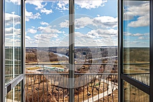 View from the balcony to the river and the industrial area with blue skies and clouds