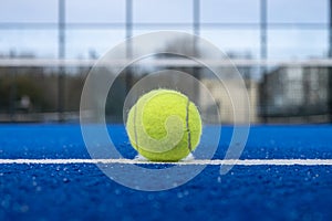 view of a ball on the baseline of a blue paddle tennis court