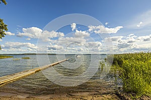 View of  Baltic Sea with  boat parked in shore on blue sky background.