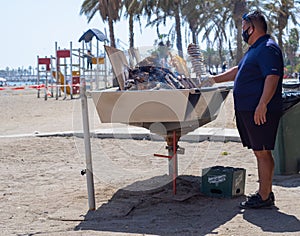 View of a barbecue grill preparing a typical fish skewer on the beaches of Malaga
