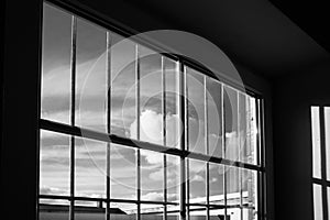 View from a barred window to the blue sky with white clouds