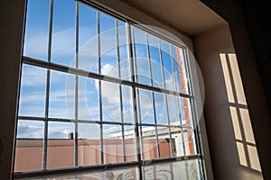 View from a barred window to the blue sky with white clouds