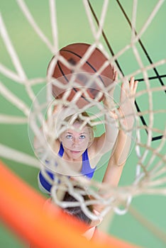 View through basketball hoop sportswoman