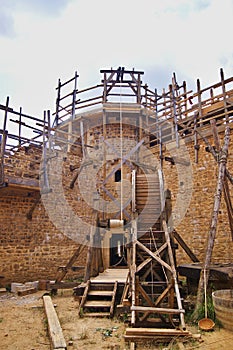 View of a bastion and a treadwheel crane at the Guedelon castle in Treigny, France. This site is actually under construction, as