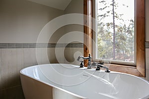 View of bathroom design with a white sleek freestanding tub photo