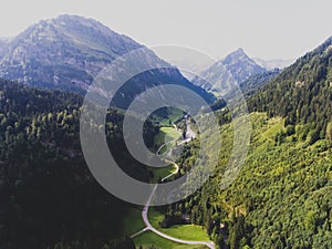 View of bavarian alpine village with a valley and mountains, shot from drone, Bayern, Bavaria, Germany, sunny summer day