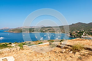 View of the bay and anchorage full of sailboats from Temple of Poseidon at Cape Sounion on sunny day, Sounion, Greece