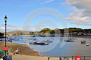 The view on a bay with a lot of boats on the river Conwy during a low tide. Conwy, Wales / United Kingdom