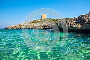 View on the beach Calo Roig with crystal water and the Defense Tower Alcaufar on Menorca photo