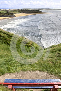 View of beach and cliffs in Ballybunion from bench