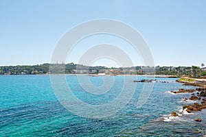View of the beach Du Ponteil of the town Antibes.with the Cap d`Antibes peninsula in the background