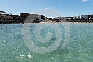 View of a beach with emerald water and dark volcanic rocks in Lobos island Canary islands