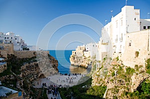 View of the beach lama monachile cala porto and white buildings on grottos and cliffs in the town of Polignano a mare