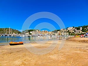 View of the beach of Port de Soller with people lying on sand, Soller, Balearic islands, Spain.