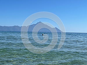 View from the beach in Sarti, with crystal clear, blue water and Mount Athos in the background