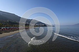 View of the beach on seaside city of Vlore. On the horizon is the Peninsula of Karaburun