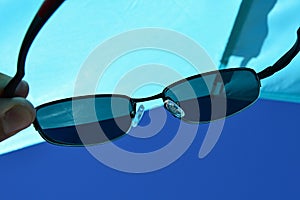 View on beach sun shield and blue skies through dioptric sunglasses with UV400 filter