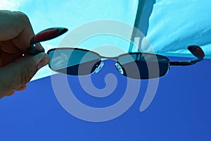 View on beach sun shield and blue skies through dioptric sunglasses with UV400 filter