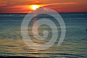 View from the beach of sunrise with cloud cover