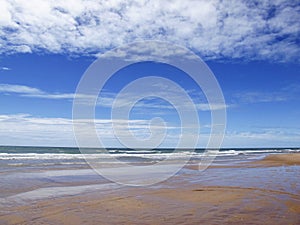 Beach and water surface of sea or ocean with horizon and blue sk photo