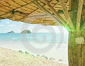 View of the beach from under the back, seaside cottage with the reflection of the sunshine