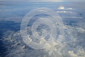 View of beautiful abstract soft white cloudscape with shades of blue sky background from flying plane window