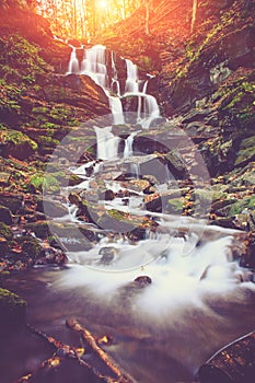 View of a beautiful autumn waterfall in mountains.