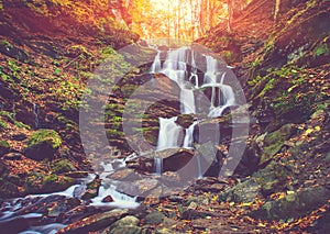 View of a beautiful autumn waterfall in mountains.