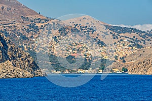 View of beautiful bay with colorful houses on the hillside of the island of Symi.