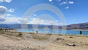 View of a beautiful blue lake in the mountains. Amazing summer landscape. Blue sky and white clouds