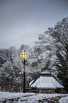 View with beautiful glowing lantern in a peaceful snow evening in the mountains