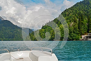 View of a beautiful lake and the Caucasus mountains from the deck of a catamaran on a sunny summer day