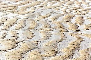 View on beautiful sandy structures and lines caused by waves on the beach