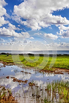 A view of a beautiful sea view in Ayia Thekla in Agia Napa, Cyprus.Reflections, a sky full of clouds