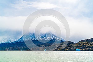 View of beautiful snow mountain covered with fog with iceberg break off Grey Glacier and floating on the Grey Lake