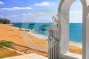View of the beautiful white wedding arch, which is located on the shore of the blue sea. Sanya China