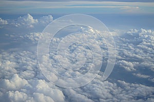 View of beautiful wide wonderland cloudscape with shades of blue sky background from flying plane window