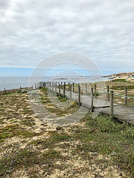 View of the beautiful wood boardwalk and the waters of the atlantic ocean in San Paio photo