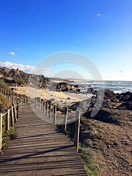 Sunny day with wood boardwalk and the Atlantic ocean in San Paio photo