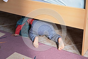 View on the bed on cute baby crawling on floor at bedroom