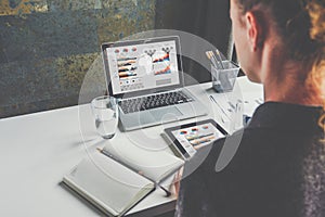 View from behind, businesswoman sitting at desk and working. Student learning online. Business planning.