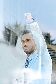 View from behind glass.confident businessman looking out the window of his office