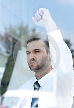 View from behind glass.confident businessman looking out the window of his office