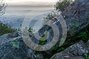 View from behind the rocks to the hills, forests and fields in the predawn fog