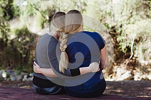 Sisters hugging each other with long hair braided togther photo